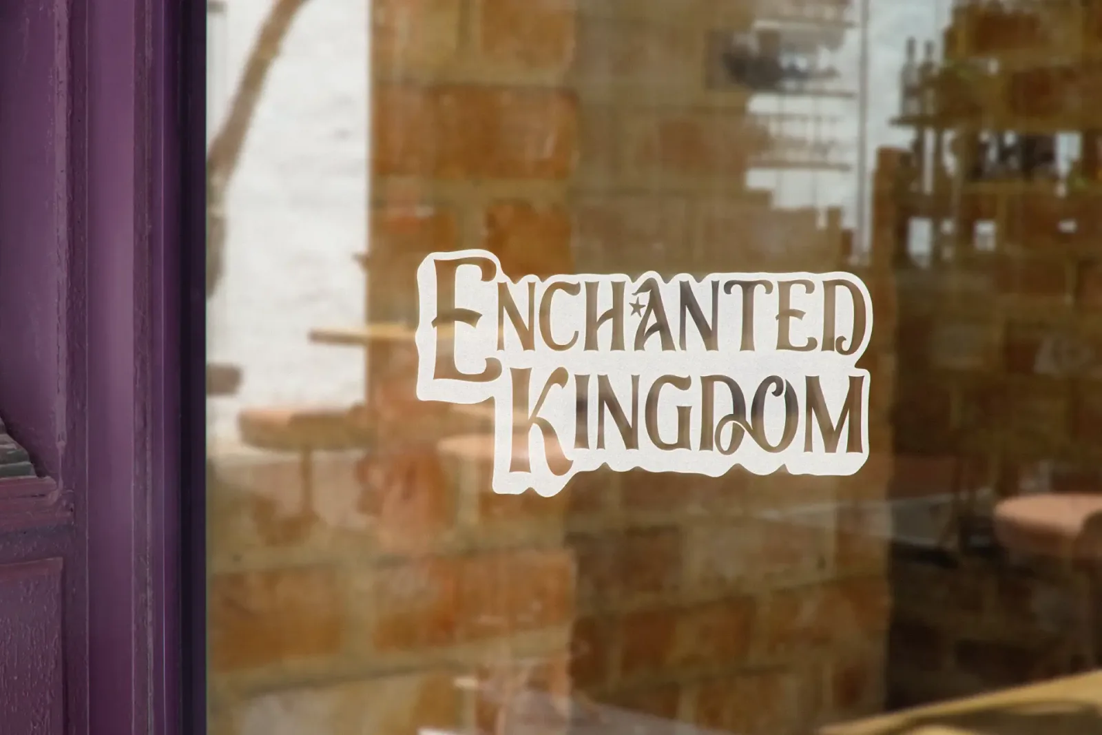 Redesigned logo of enchanted kingdom on a window of an establishment mockup